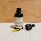 Bottle of Honeybee Hippie hair and beard oil with natural ingredients, showcasing the product label and dropper applicator.