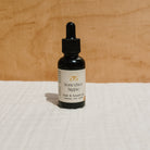 Bottle of Honeybee Hippie hair and beard oil with natural ingredients, showcasing a sleek, amber-colored glass container.