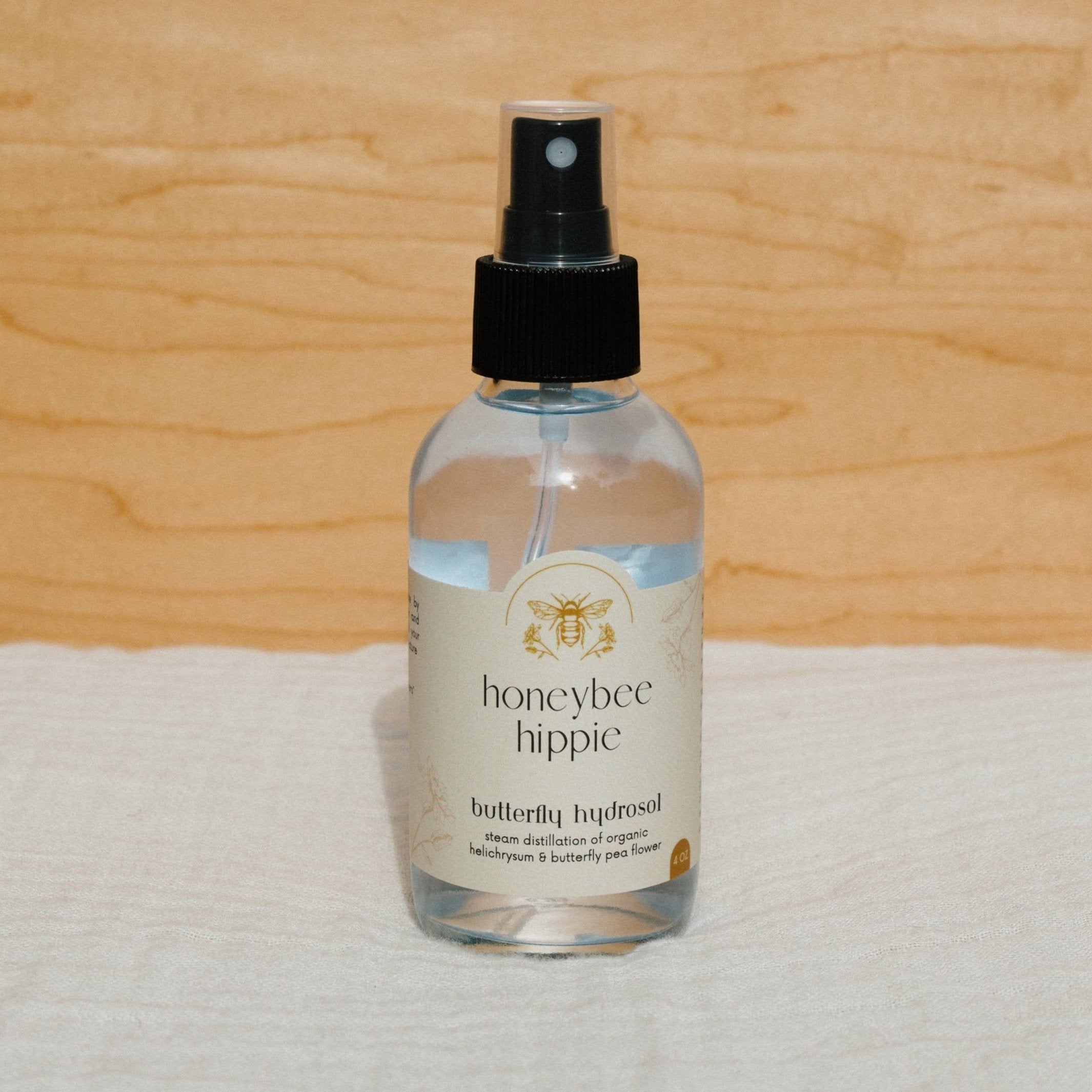 Bottle of Butterfly Hydrosol from Honeybee Hippie, natural floral hydrosol with butterfly illustration on label.