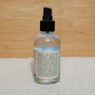 Butterfly hydrosol by Honeybee Hippie, a natural floral water with a clear bottle and label, showcasing the product in a glass container.