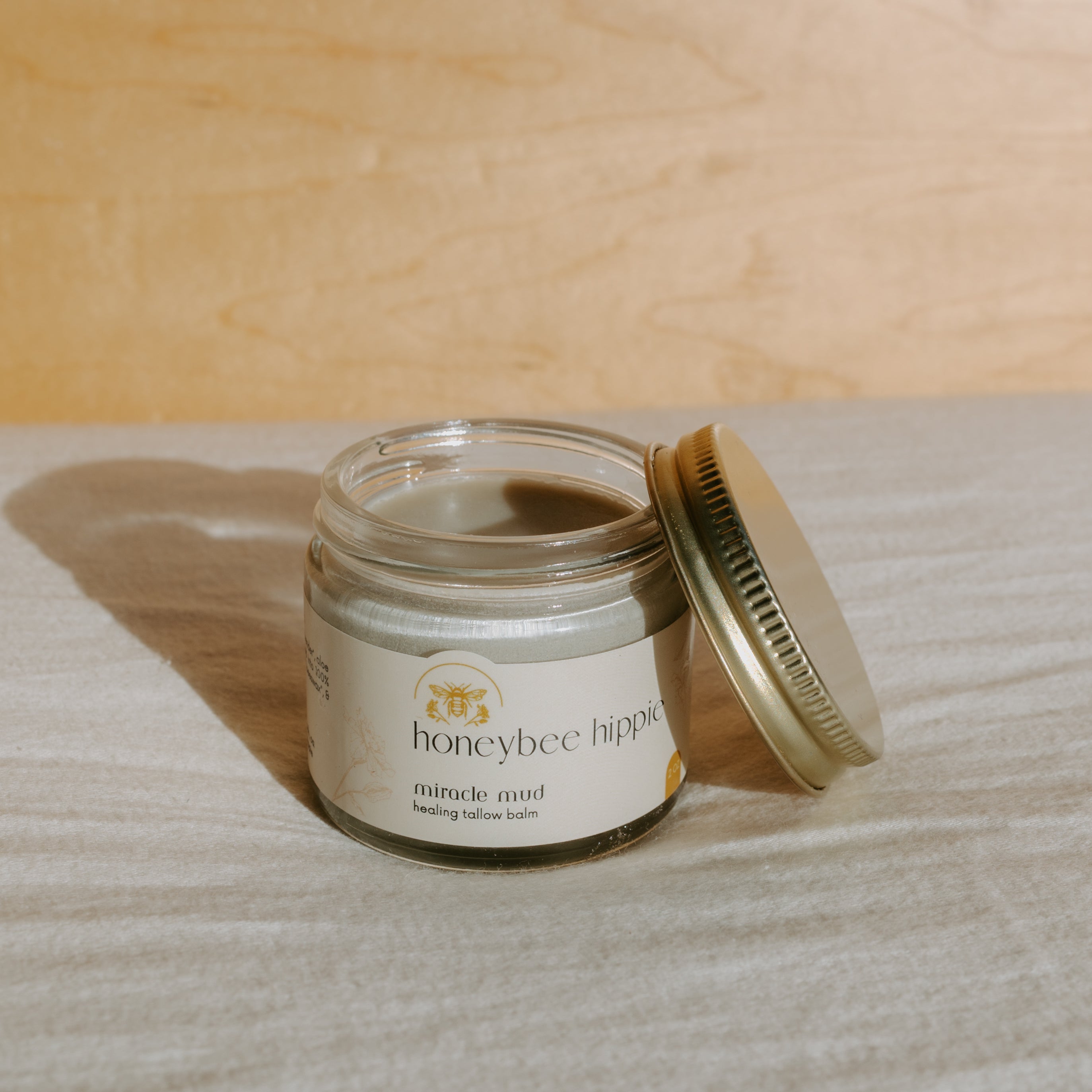 Honeybee Hippie Miracle Mud jar with natural clay and herbal ingredients for skincare benefits.