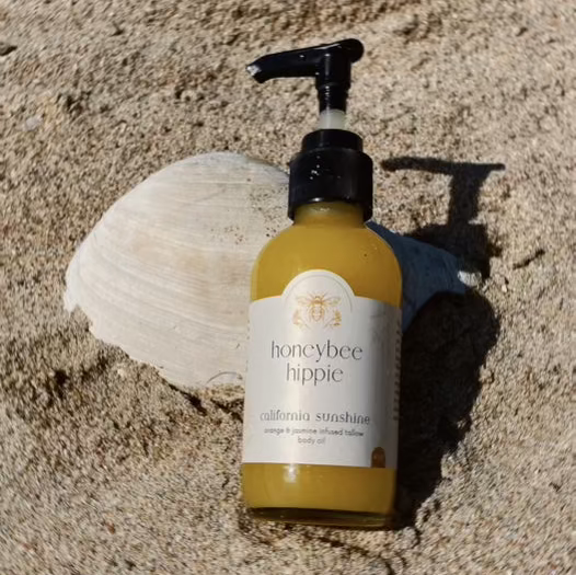 Honeybee Hippie California Sunshine Tallow Body Oil bottle with golden liquid and natural ingredients visible.