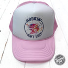 Foam trucker cap branded The Graphic Tee with "Hookin' Ain't Easy" slogan, featuring a structured front panel and mesh back.