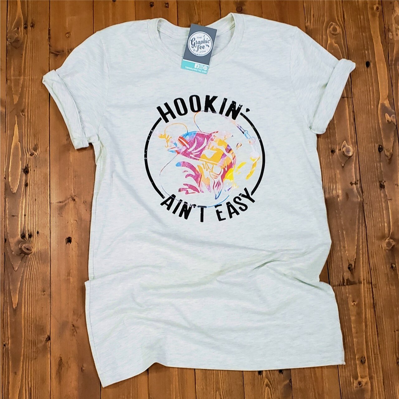 Heather Prism Natural SS Graphic Tee from The Graphic Tee featuring a Hookin' Ain't Easy design on a casual cotton shirt.