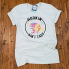Heather Prism Natural SS Graphic Tee from The Graphic Tee featuring a Hookin' Ain't Easy design on a casual cotton shirt.
