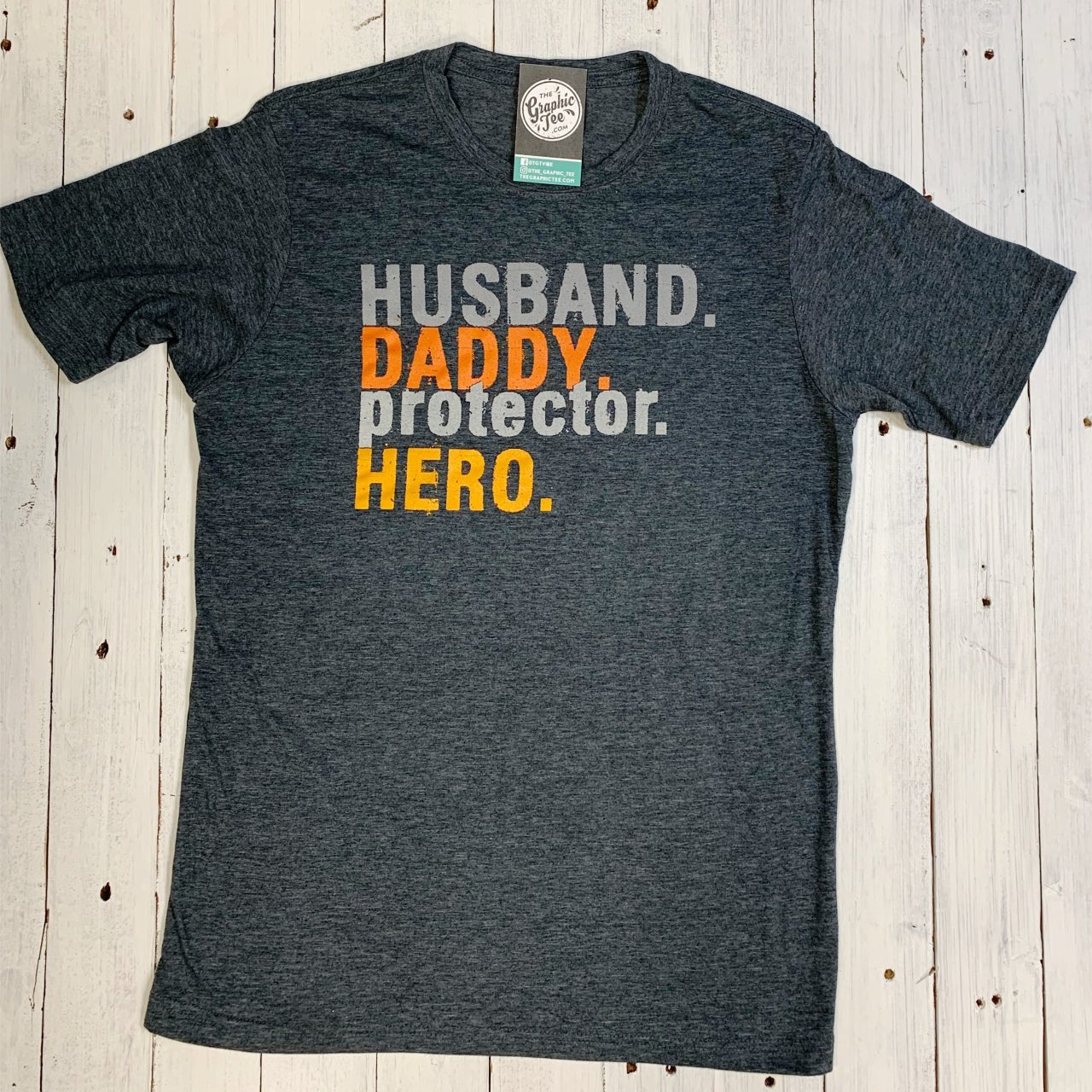 Father and husband superhero graphic tee from The Graphic Tee featuring a protective hero design on a casual SS T-shirt.