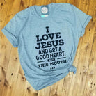 Grey graphic T-shirt by The Graphic Tee featuring the text "I Love Jesus and Got A Good Heart, but This Mouth" on the front.