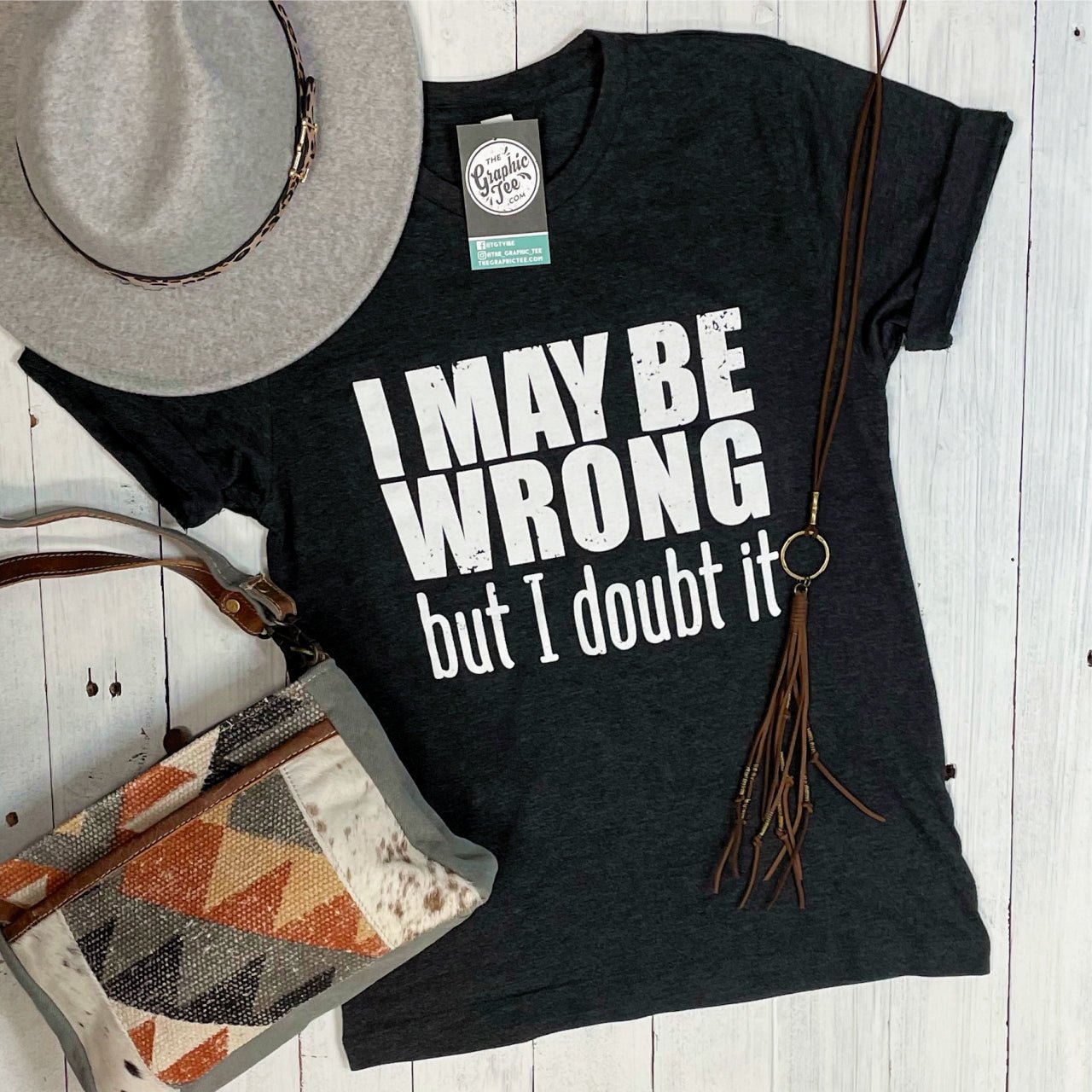 Unisex SS graphic tee from The Graphic Tee featuring the humorous "I May Be Wrong But I Doubt It" slogan on cotton fabric.