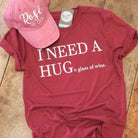 White short-sleeve graphic T-shirt featuring a humorous "I Need a HUGe glass of wine" Vino Red design by The Graphic Tee.