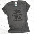 White V-neck T-shirt from The Graphic Tee featuring humorous "I Need to Teach My Facial Expressions" graphic design.