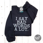 Black adult crewneck sweatshirt with "I Say Bad Words A Lot" graphic, from The Graphic Tee, casual and comfortable.