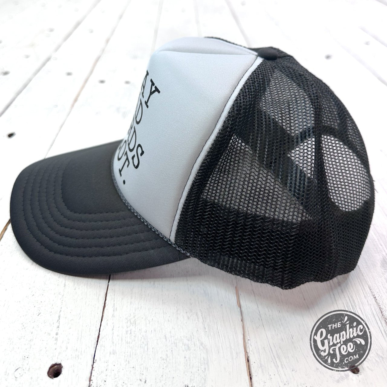Black foam trucker cap with "I Say Bad Words A Lot" embroidered text on front, featuring mesh back panels and adjustable strap.
