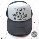 Black foam trucker cap with bold white text saying "I Say Bad Words A Lot" by The Graphic Tee, adjustable snapback style.