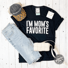 Black short-sleeve graphic tee for women with "I'm Mom's Favorite" print by The Graphic Tee. Casual, stylish women's T-shirt.