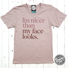 Black V-neck graphic t-shirt by The Graphic Tee reading "I'm Nicer Than My Face Looks" in bold white letters.