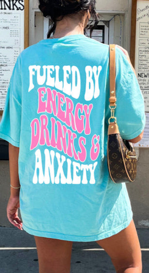 Graphic tee from Shop Karma Tees featuring design inspired by Fueled By Energy Drinks and Anxiety, with bold text and vibrant colors.