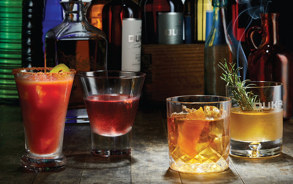 Hardcover of John Wayne: The Official Cocktail Book by Insight Editions, featuring illustrated pages and cocktail recipes.