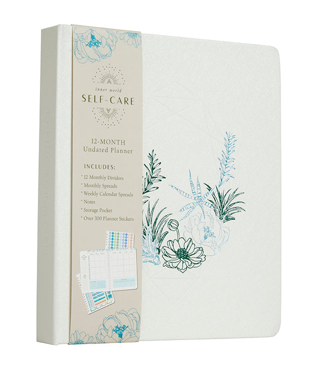 Hardcover Insight Editions Self-Care 12-Month Undated Planner with colorful cover design and spiral binding.