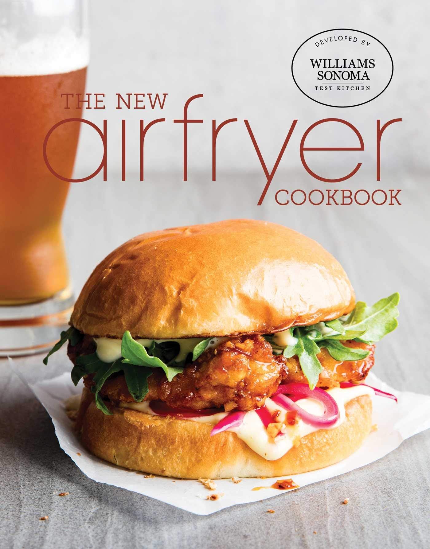 Hardcover Insight Editions cookbook titled "The New Air Fryer Cookbook" with colorful food images on the cover.