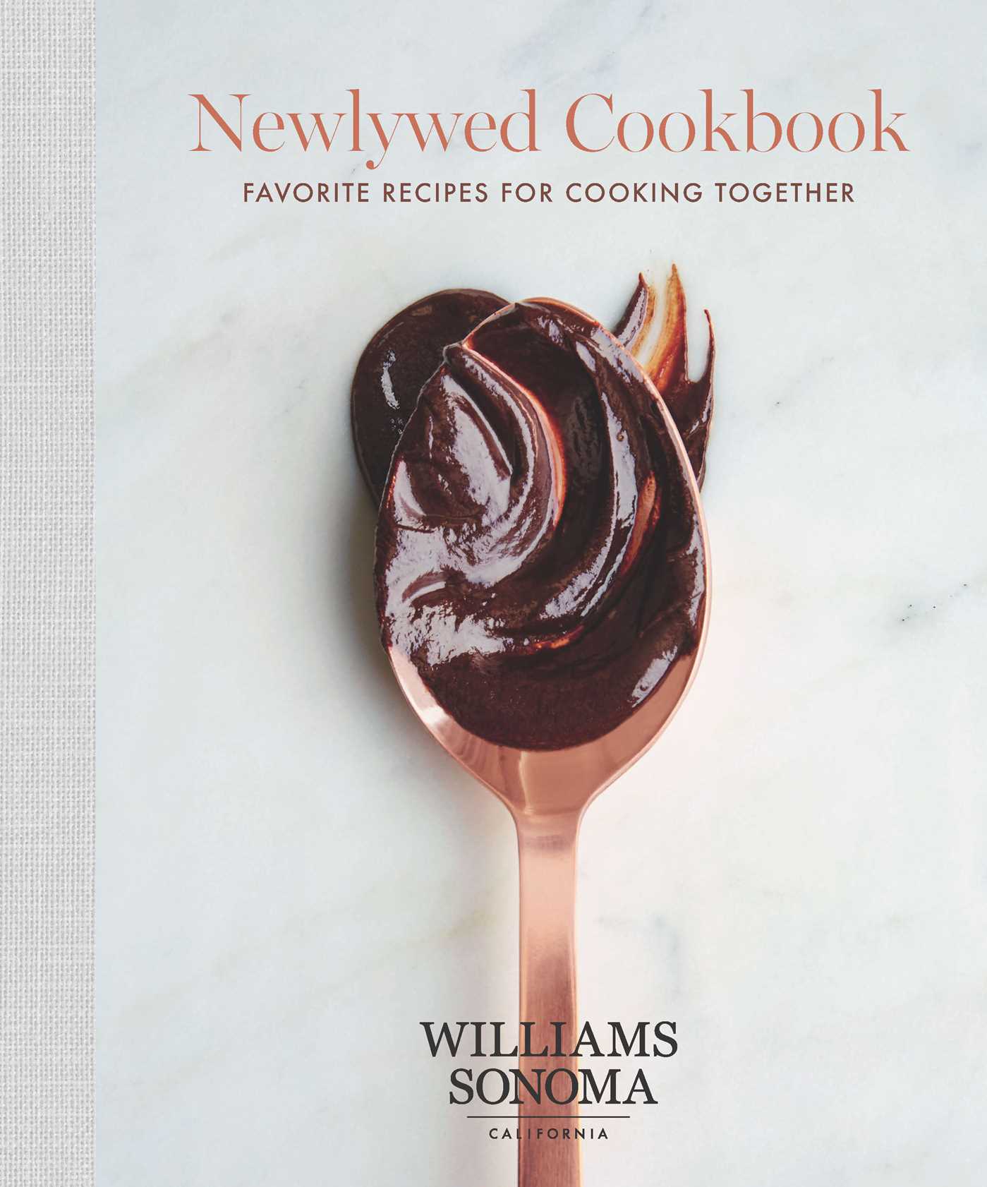 Hardcover copy of The Newlywed Cookbook by Insight Editions, featuring a cozy kitchen scene with recipe pages and cooking utensils.