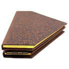 Open hardcover journal titled "Wicked: The Grimmerie" with decorated pages and ornate design, published by Insight Editions.
