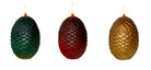 Set of three sculpted dragon egg candles from Game of Thrones by Insight Editions, featuring detailed textured surfaces and warm candlelight.