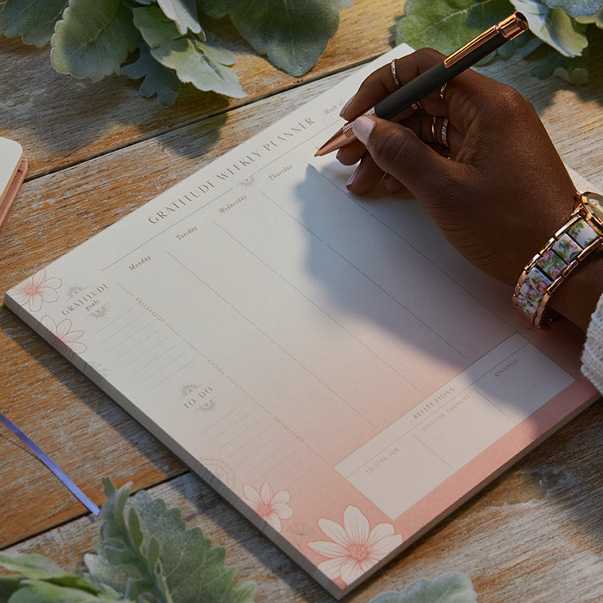 Insight Editions Gratitude Weekly Planner Notepad showing pages with daily gratitude prompts and weekly organization layout.