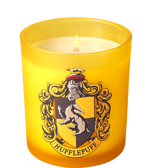 Hufflepuff scented glass candle from Harry Potter home goods collection, featuring a decorative Hufflepuff crest and warm candle inside.