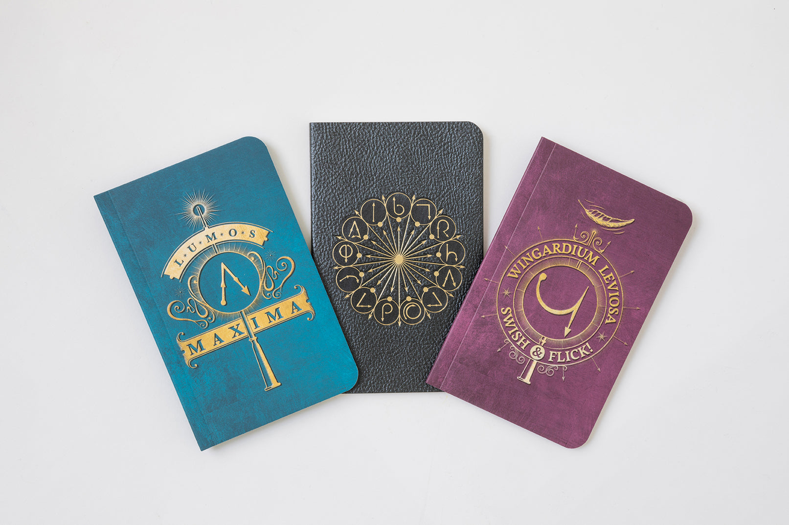 Set of three Harry Potter softcover pocket notebooks from Insight Editions featuring spell-themed covers, ideal for note-taking or collection.