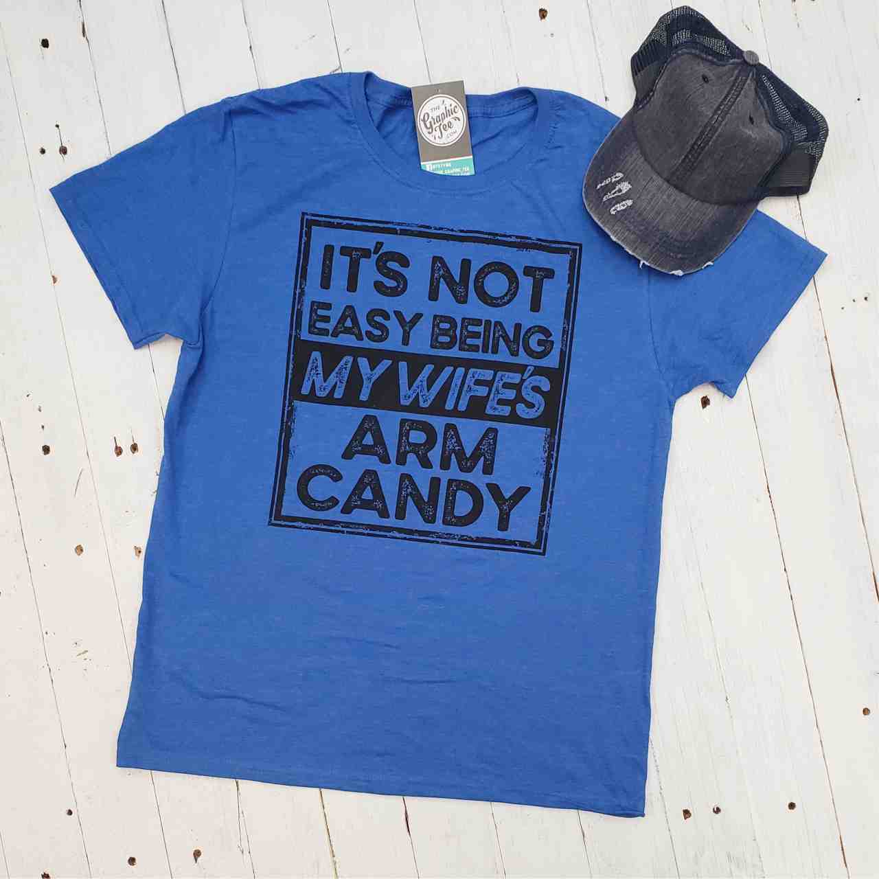 Gray adult graphic tee from The Graphic Tee featuring the humorous "It's Not Easy Being My Wife's Arm Candy" design.