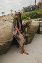 Jennafer Grace Actius Kaftan dress in Taj with flowing fabric and intricate patterns, displayed on a hanger against a neutral background.