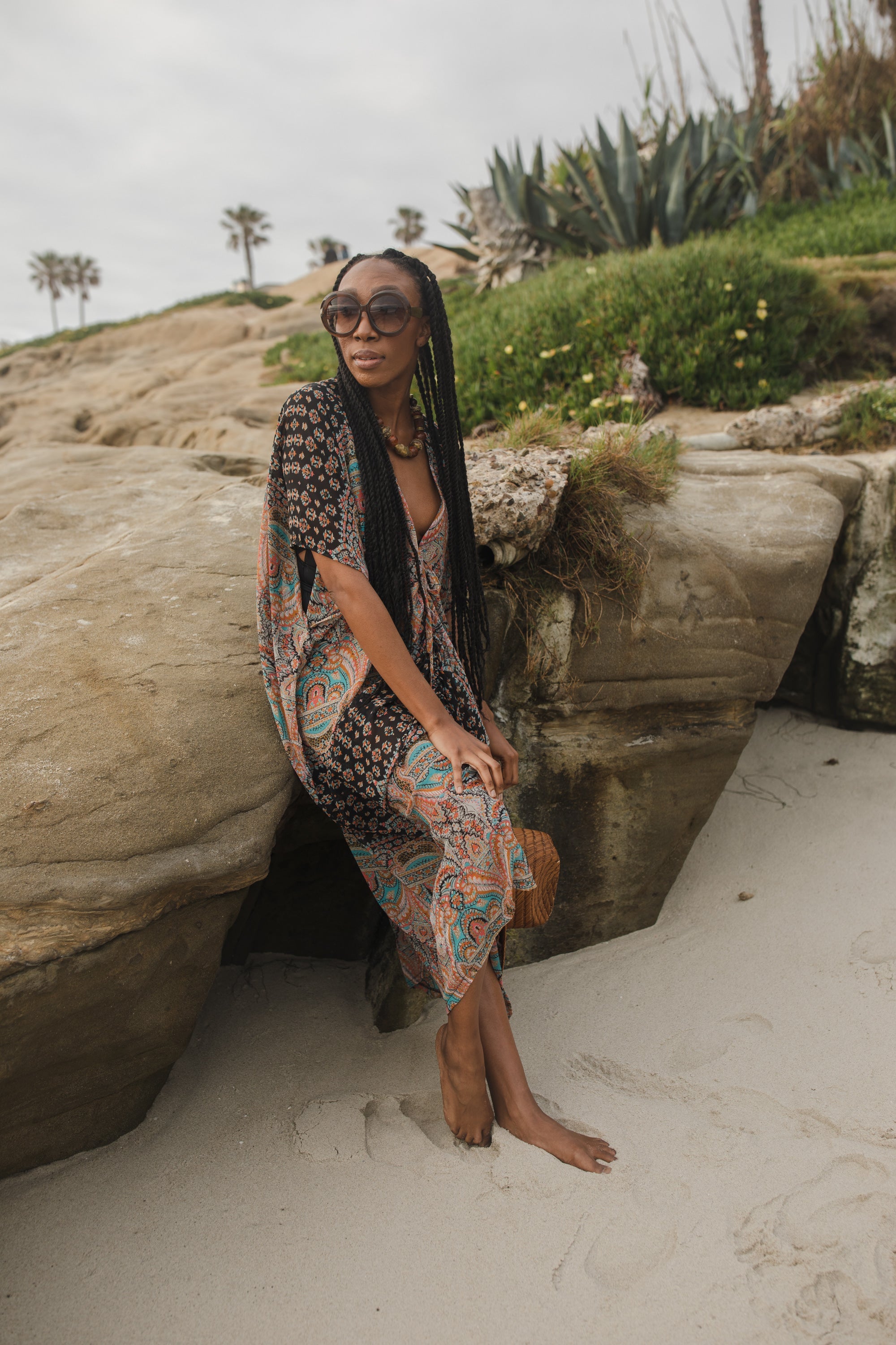 Jennafer Grace Actius Kaftan dress in Taj with flowing fabric and intricate patterns, displayed on a hanger against a neutral background.
