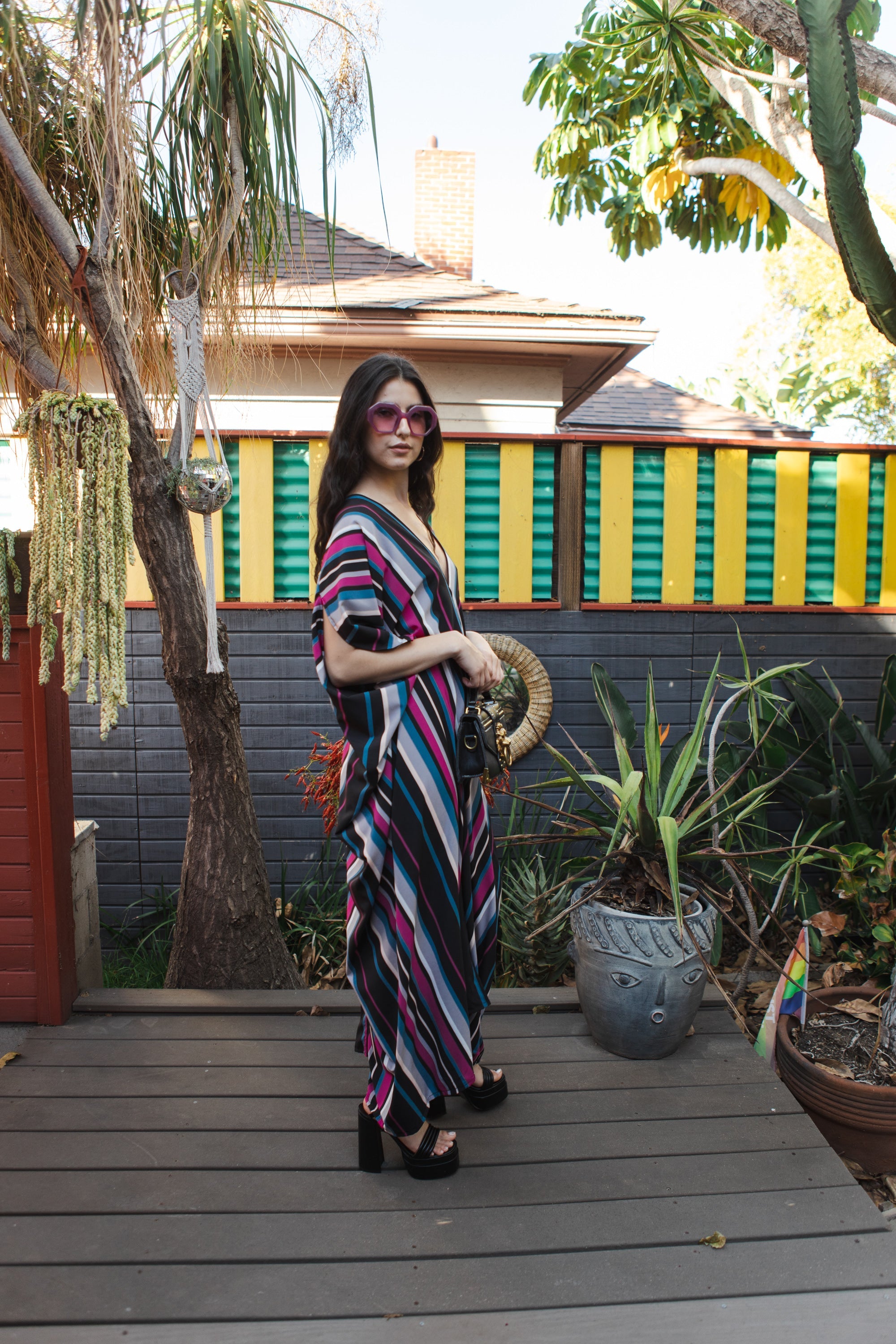Raspberry stripe kaftan dress by Jennafer Grace, handmade with flowing fabric and vibrant pattern, displayed on a hanger.