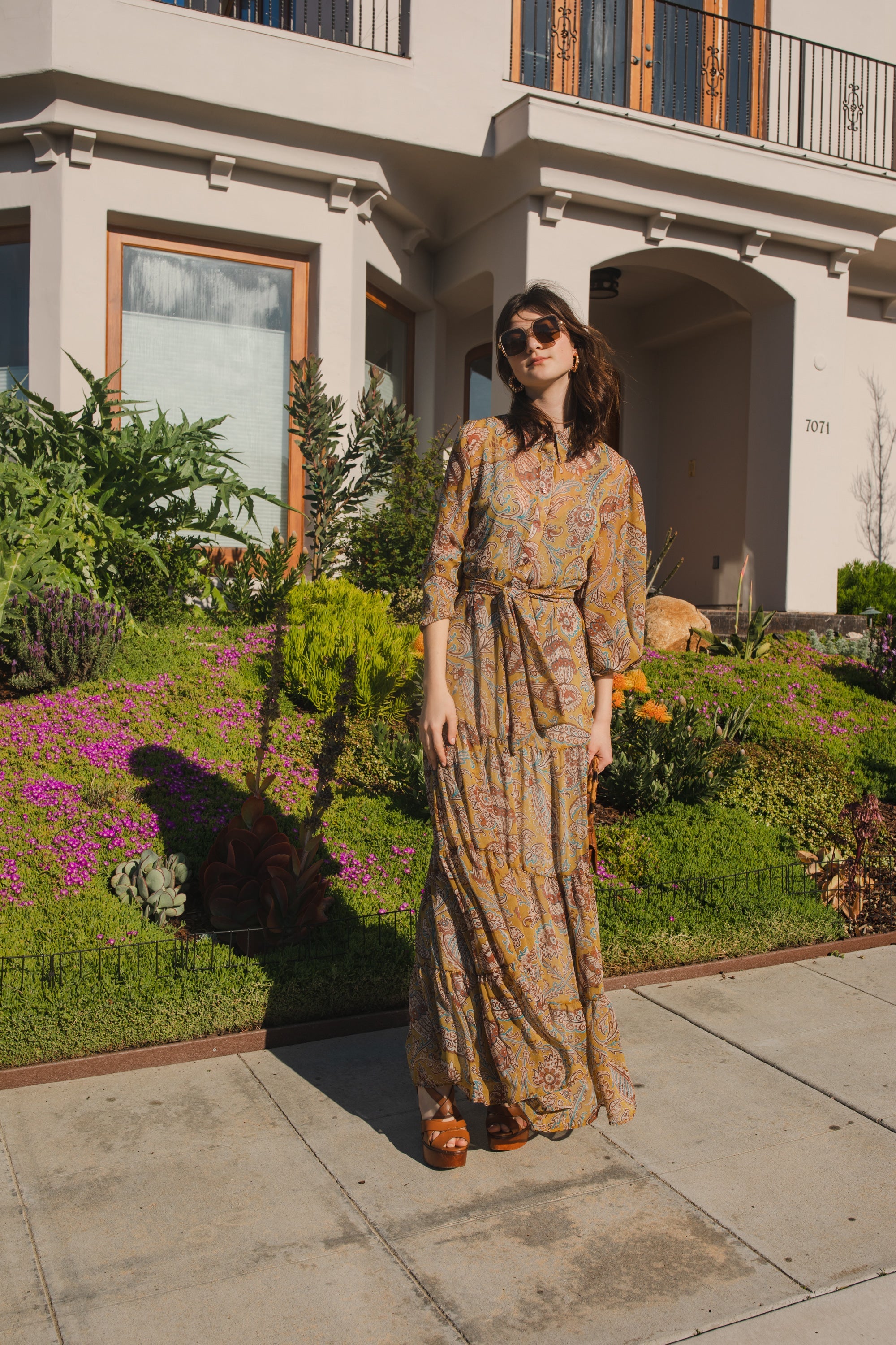 Handmade Jennafer Grace Agnes Bookie Maxi Dress with floral pattern and flowing fabric, displayed on a hanger.
