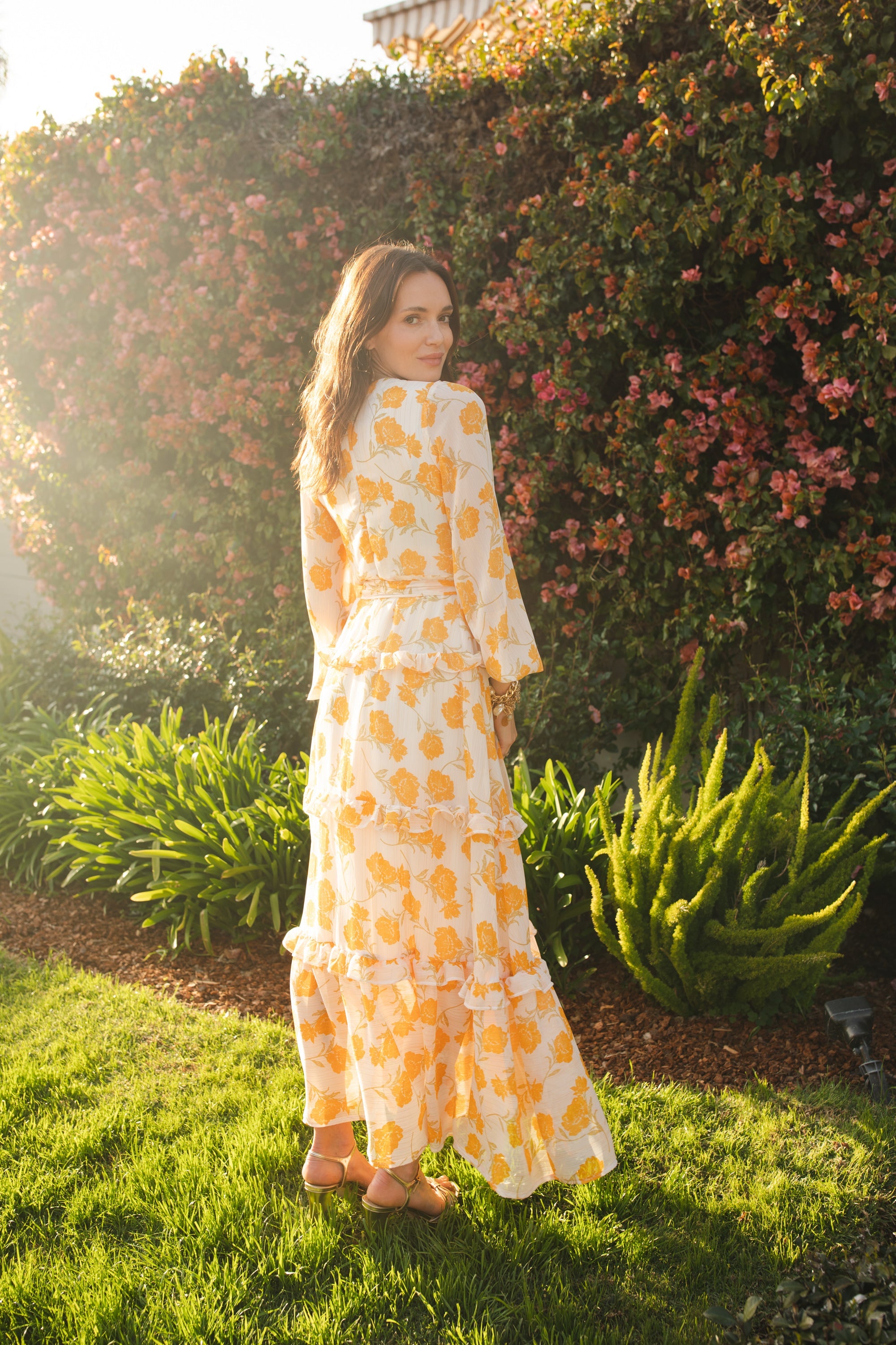 Elegant yellow Jennafer Grace Love Maxi Dress displayed on a hanger with flowing fabric and floral accents, perfect for summer wear.