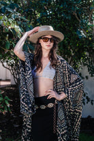 Handmade Antoinette Kimono by Jennafer Grace featuring intricate crochet details and flowing fabric, displayed on a hanger.