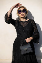 Black sequin lace ruffle dress by Jennafer Grace featuring intricate lace details and flowing ruffle accents.