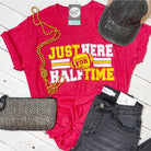 Unisex graphic tee by The Graphic Tee featuring "Just Here For Halftime" design, casual short-sleeve t-shirt on a plain background.