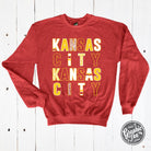 Kansas City multi-pattern letters heather sport scarlet crewneck sweatshirt by The Graphic Tee, front view showing vibrant graphic design.