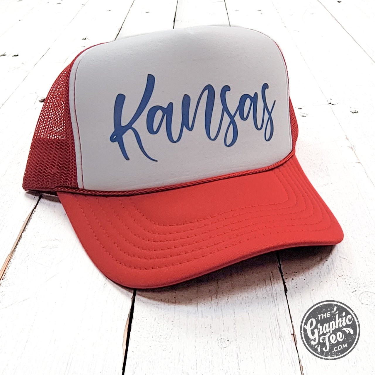 Kansas Red and White Foam Trucker Cap by The Graphic Tee, featuring a classic trucker style with bold Kansas colors and mesh back.