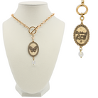 Katia Designs butterfly choker necklace in antique gold with "She Believed She Could" engraved, stylish jewelry accessory on a model.