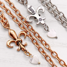 Katia Designs antique gold Love Fleur-de-Lis essential necklace with intricate pendant and chain on a plain background.