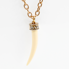 Katia Designs Love Tusk Essential Necklace featuring an antique gold pendant on a delicate chain.