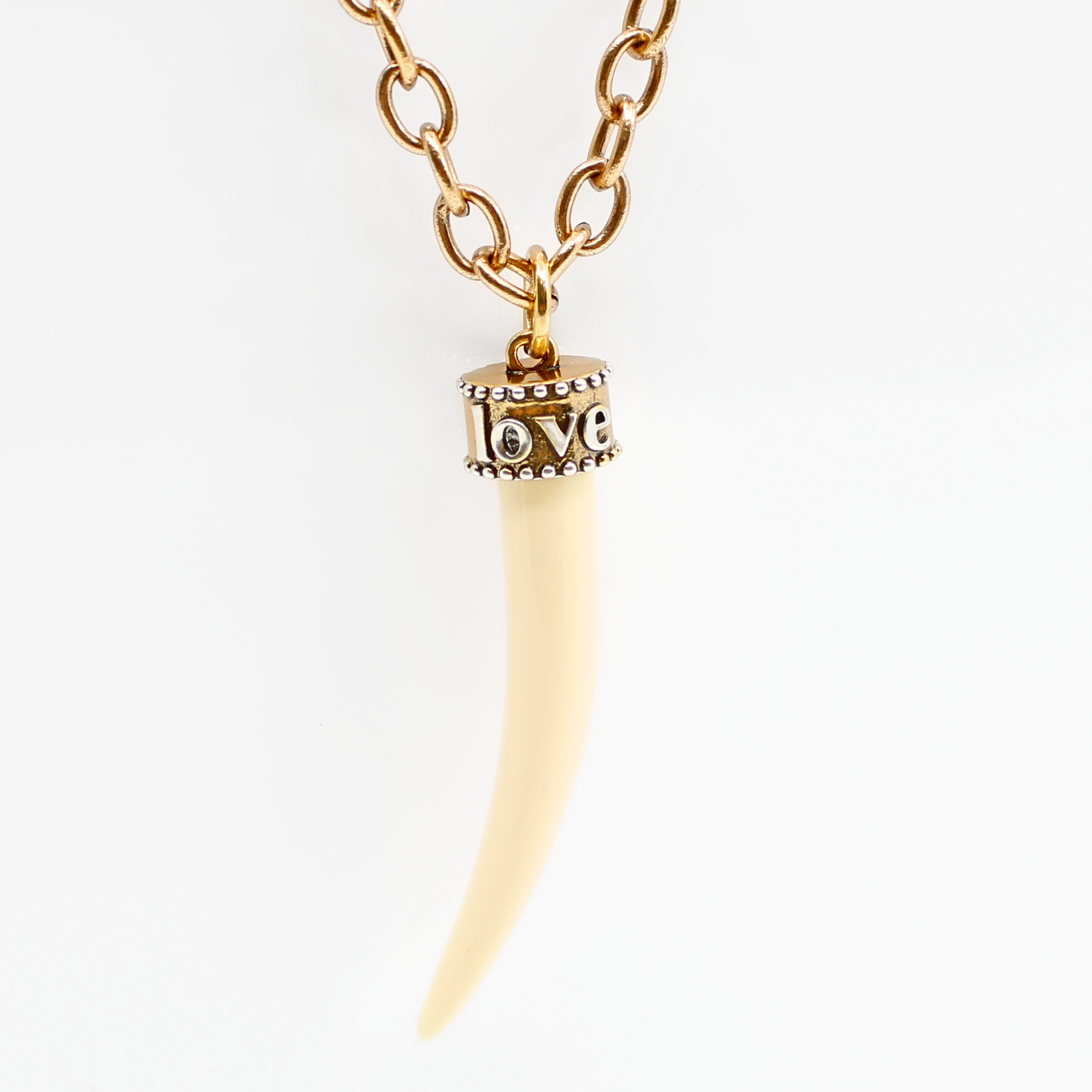 Katia Designs Love Tusk Essential Necklace featuring an antique gold pendant on a delicate chain.