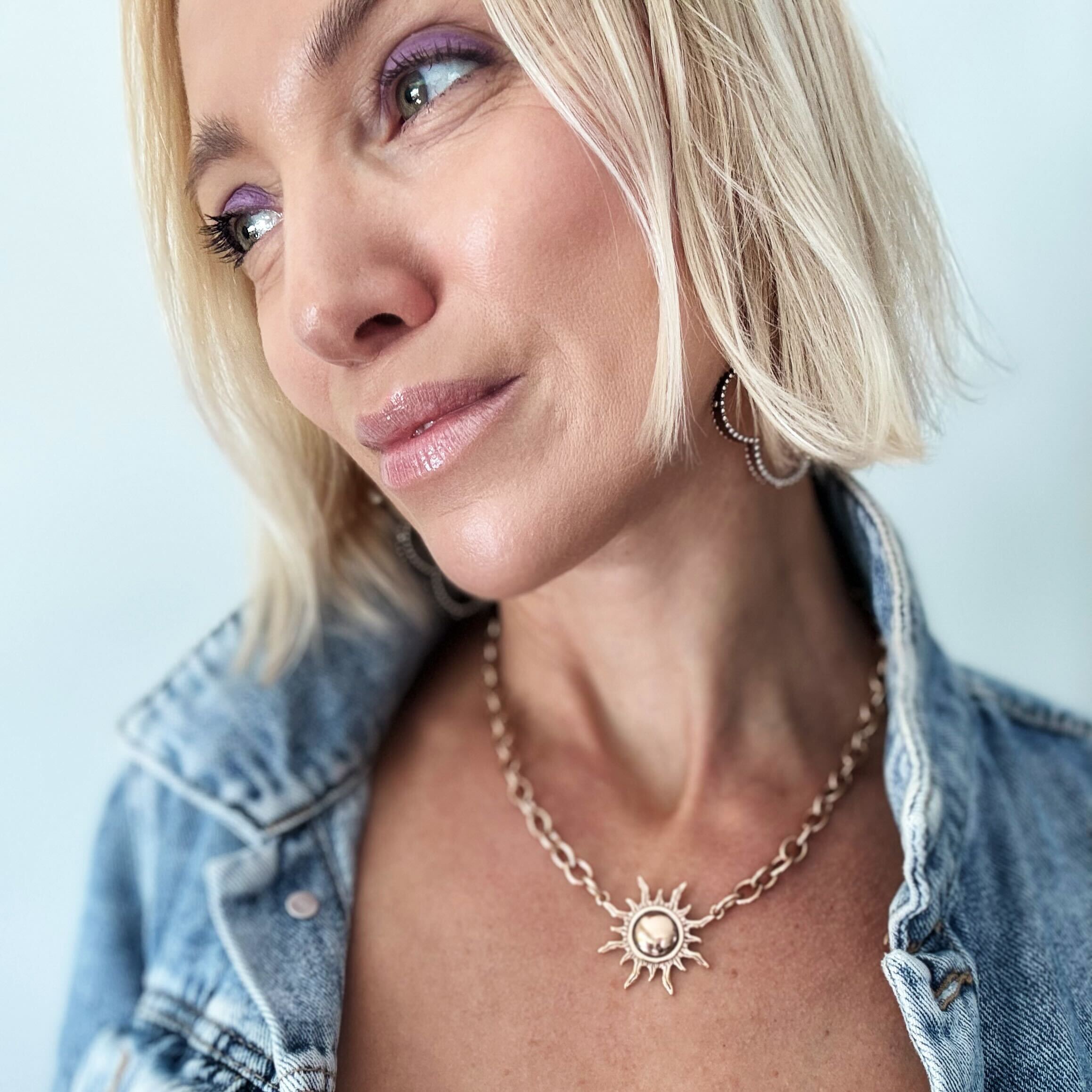 Antique gold midi choker necklace featuring a sun charm from Katia Designs, styled with a delicate chain design.