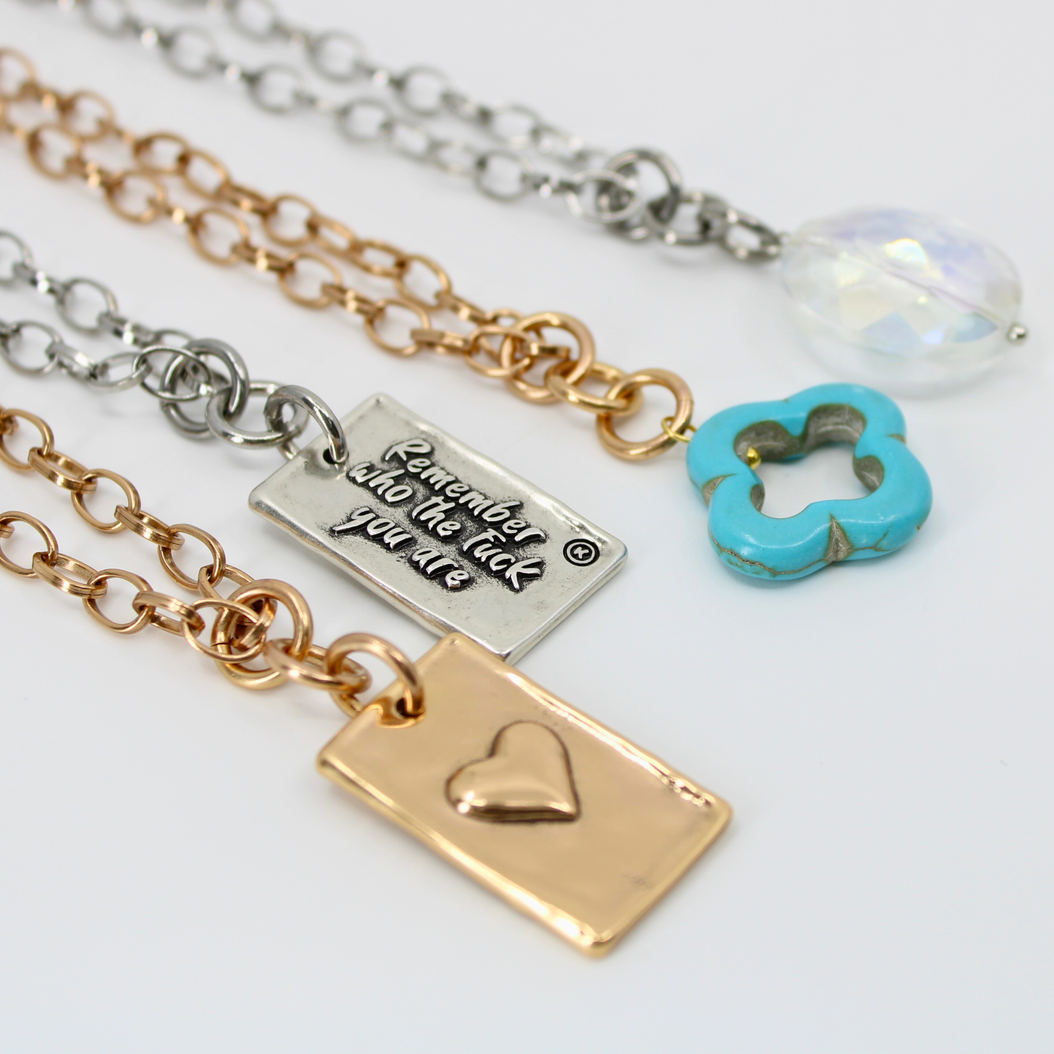Antique gold Katia Designs original Lite necklace with a clover and howlite pendant, engraved with "Remember Who the F*ck You Are."