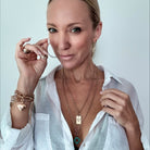 Katia Designs original lite necklace with antique gold finish, featuring a howlite clover and engraved message "Remember Who the F*ck You Are."