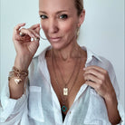 Katia Designs original Lite necklace with antique gold finish and smoky crystal, featuring engraved “Take a Deep Breath and Let That Shit Go.”