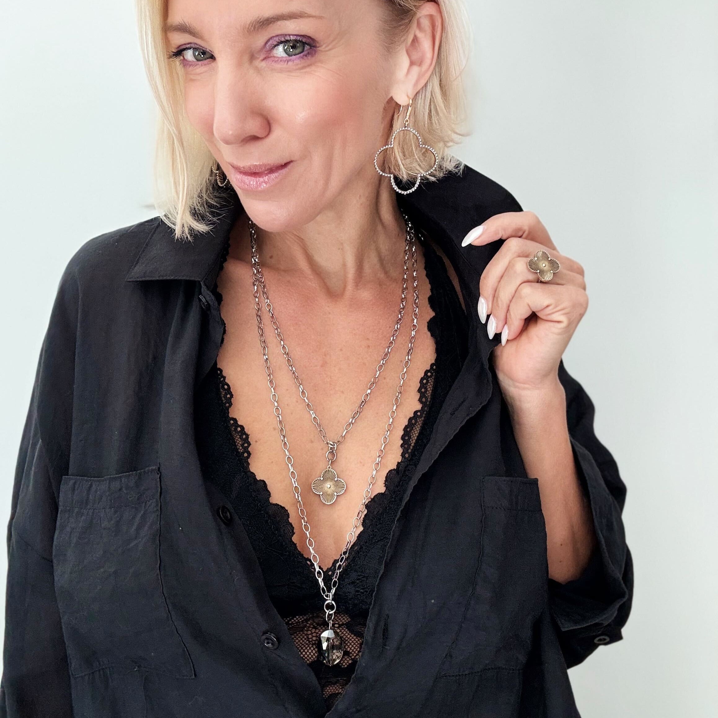 Katia Designs All is Well Clover Original Lite necklace with a silver chain and smoky crystal pendant featuring a clover design.