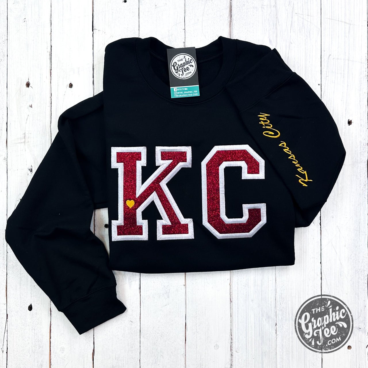 Black crewneck sweatshirt by The Graphic Tee with red glitter applique design on the front.